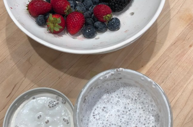 bowl containing berries and jar of chia pudding with the lid removed