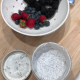 bowl containing berries and jar of chia pudding with the lid removed